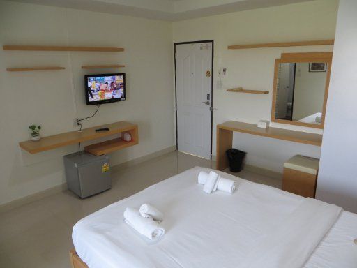 Baan San Poom, Phitsanulok, Thailand, Zimmer 26 mit Flachbildfernseher, Ablage, Kühlschrank und Eingangstür