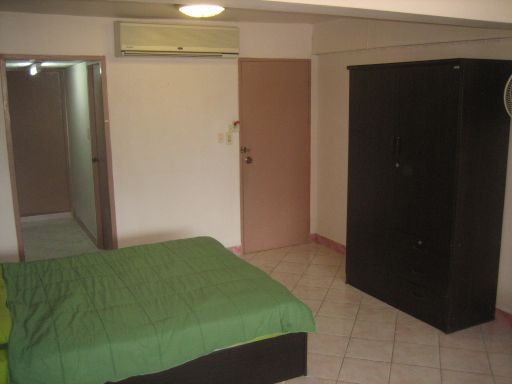Dolphin Apartment, Zimmer Nummer 12, Pattaya, Thailand, Schlafzimmer mit Klimaanlage, Schrank und Eingangstür