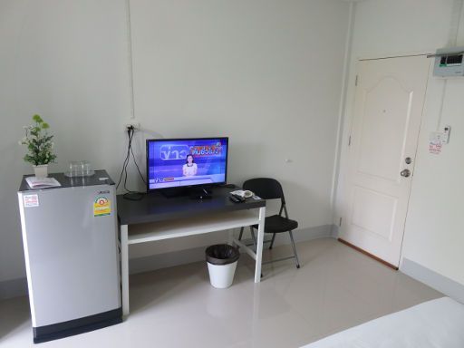 Honghub Sakon Hotel, Sakon Nakhon, Thailand, Zimmer 14 mit Kühlschrank, Flachbildfernseher, Tisch, Stuhl und Eingangstür