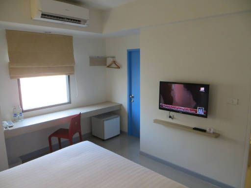 HOP INN Hotel, Khon Kaen, Thailand, Zimmer 209 mit Tisch, Fenster, Stuhl, Kühlschrank, Garderobe, Tür nach außen zur Klimaanlage und Flachbildfernseher