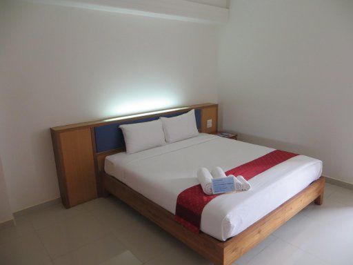 J2 Hotel, Mae Sot, Thailand, Zimmer 102 mit Doppelbett, Nachttisch, indirekte Beleuchtung, zwei großen und zwei kleinen Handtüchern