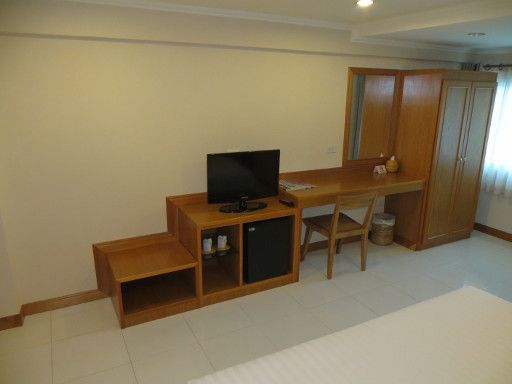 Muanmanee Boutique Hotel, Loei, Thailand, Zimmer 211 mit Kofferablage, Fernseher, Kühlschrank, Wandtisch, Spiegel, Stuhl und Schrank