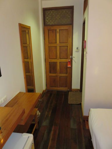 Sukkasem Hotel, Nan, Thailand, Zimmer 310 mit Eingangstür, Holzdielenfußboden und Tür zum Badezimmer