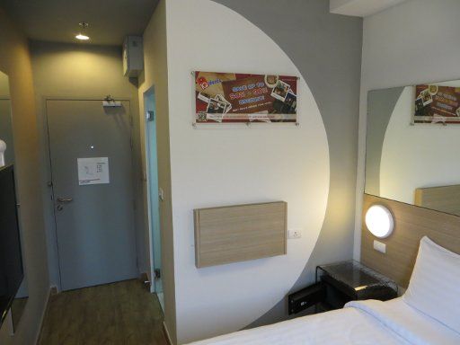 Tune Hotel, Patong, Phuket, Thailand, Zimmer 723 mit Klapptisch, Mini Safe, Eingangstür, großer Wandspiegel, Föhn und Tür zum Badezimmer